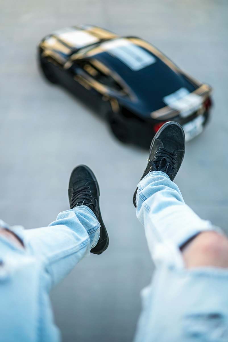 apparel shallow focus photography unknown person in blue distressed jeans and black sneakers clothing