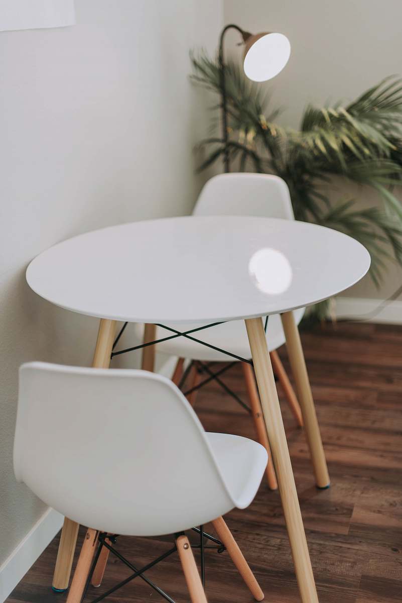 table round white wooden 3-piece bistro set beside floor lamp dining table