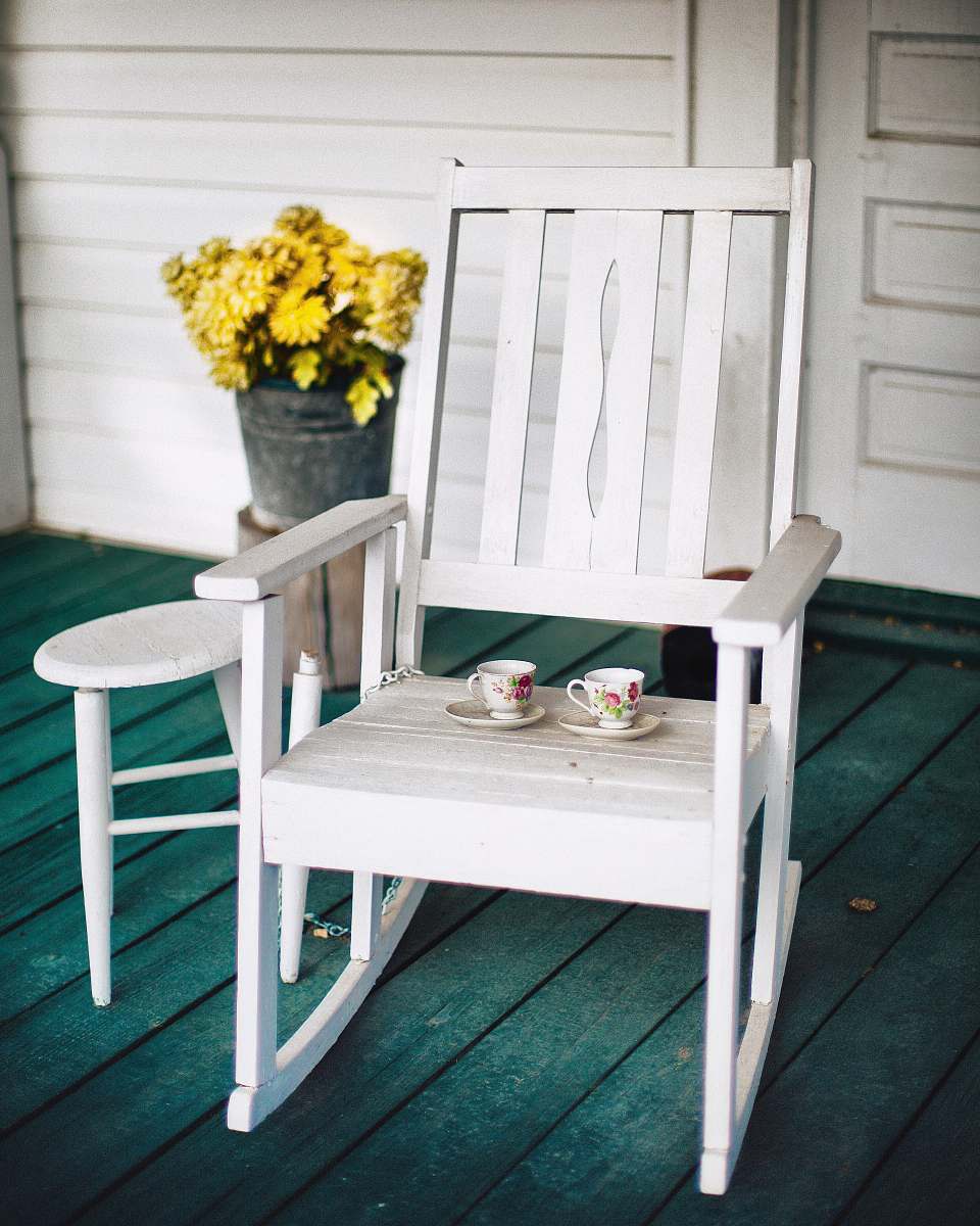 chair two white and pink floral ceramic teacups and saucers on white wooden rocking chair rocking chair