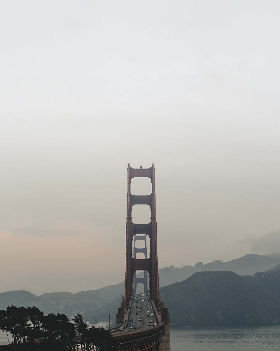 building brown gate bridge near hills and trees bridge