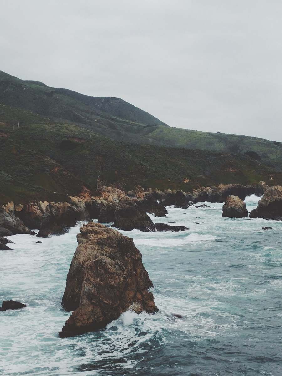 ocean brown rock on body of water near mountain big sur