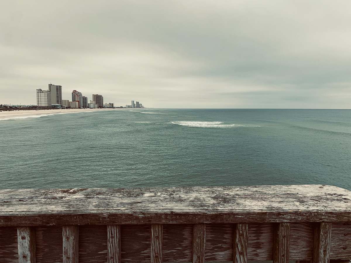 building brown wooden fence near body of water during daytime water