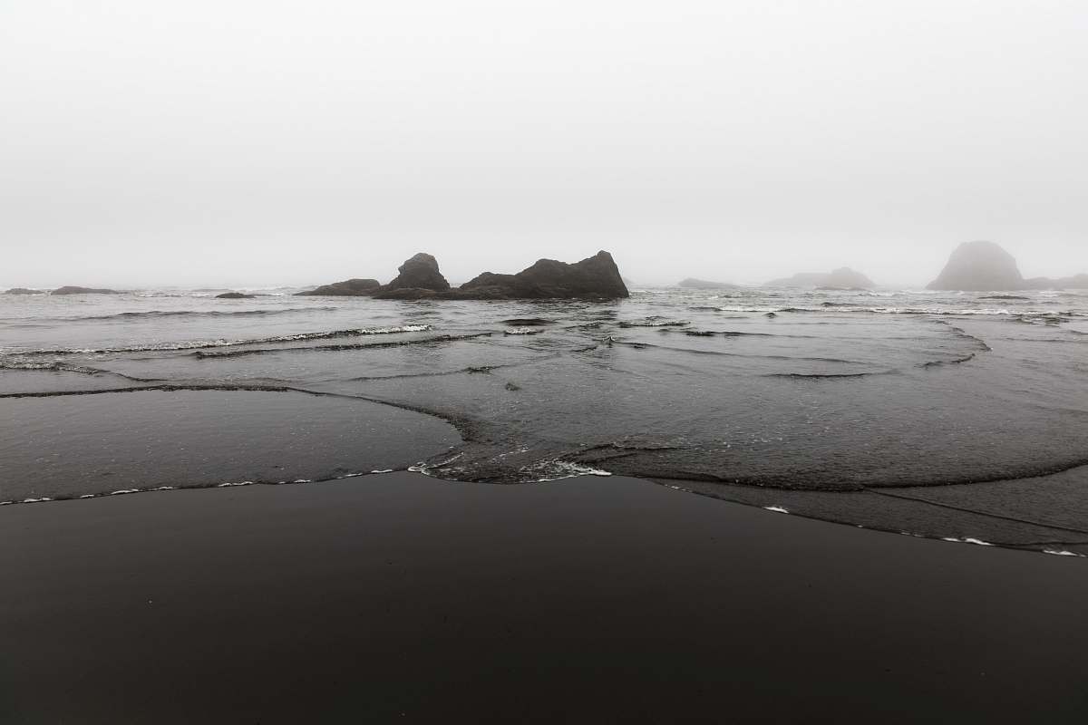 black-and-white island near body of water sand