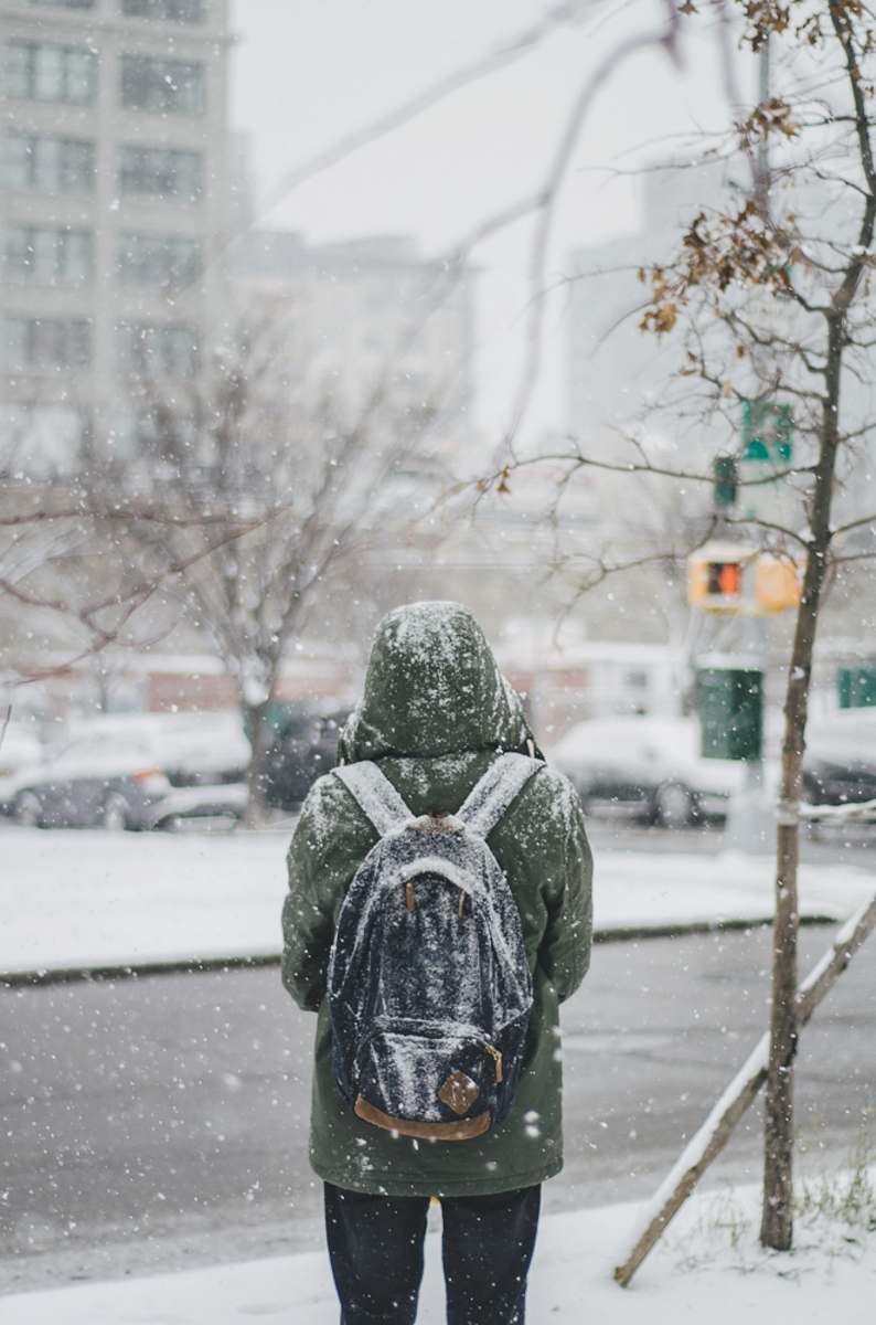 brooklyn person standing under pouring snow snow