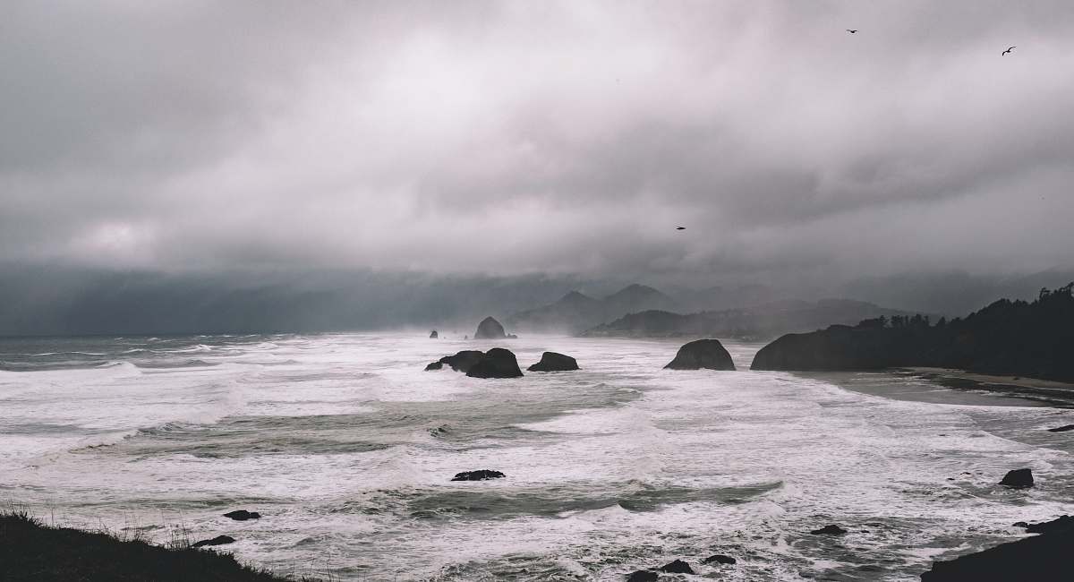 nature rock formations between sea under gray sky sea
