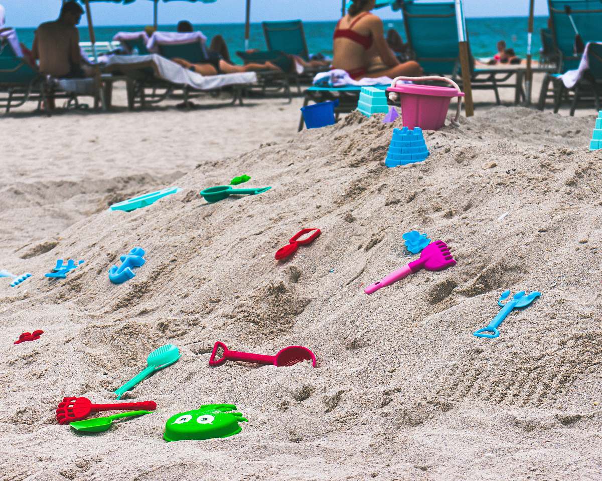 person assorted-color toys on sand sand