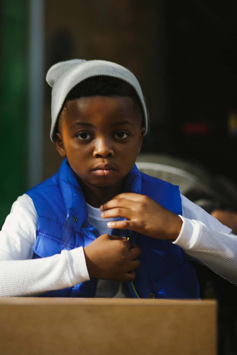 person boy in blue and white long sleeve shirt wearing white and black knit cap new york