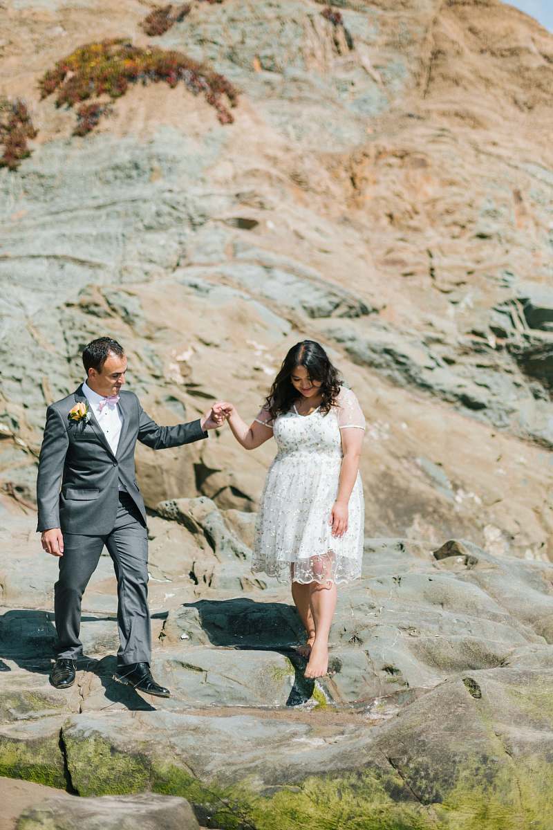 person couple walking beside rock formation suit