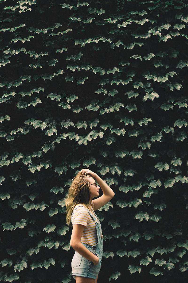 person girl standing beside tree holding her hair people