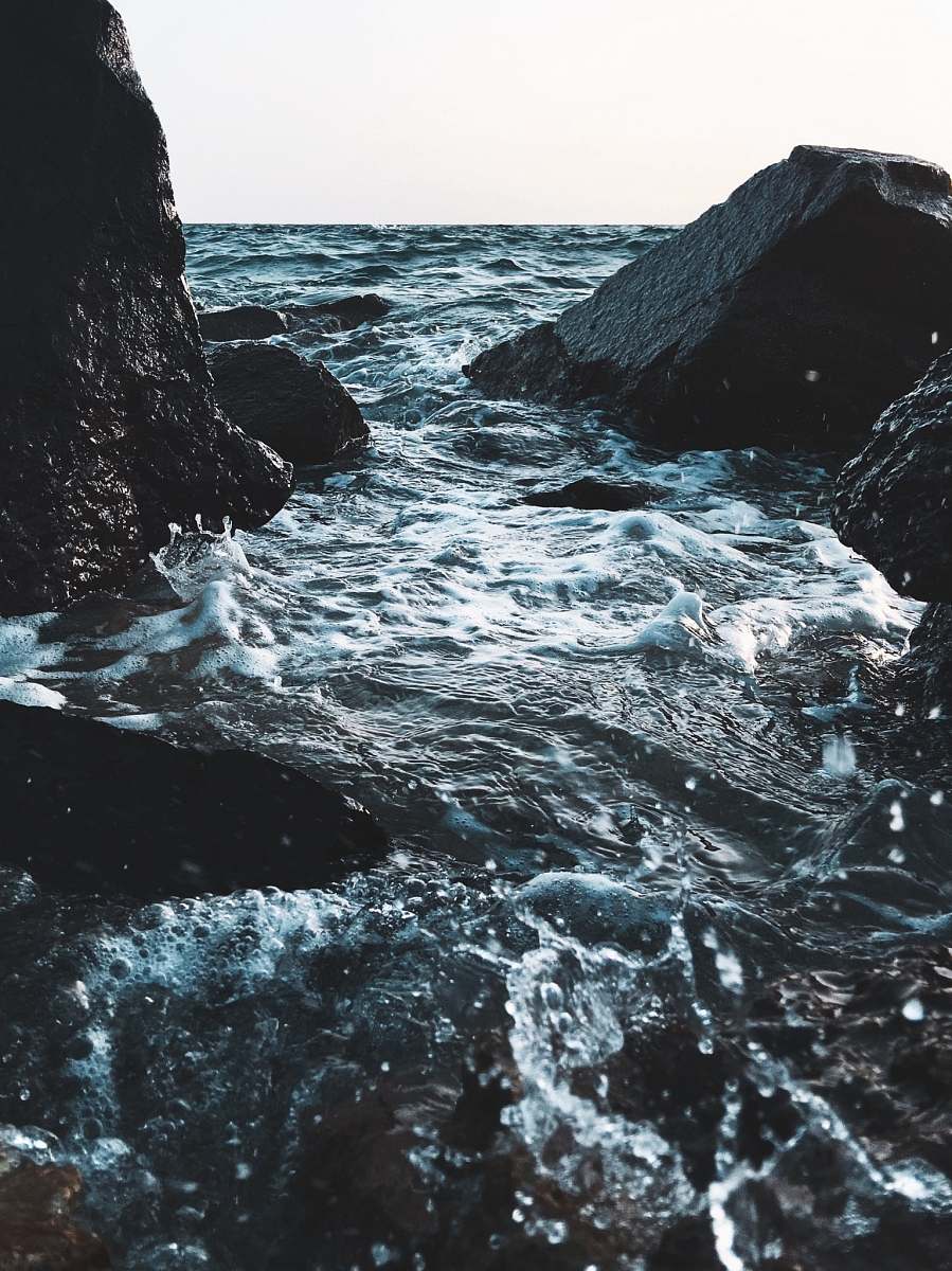 people gray stones near body of water person