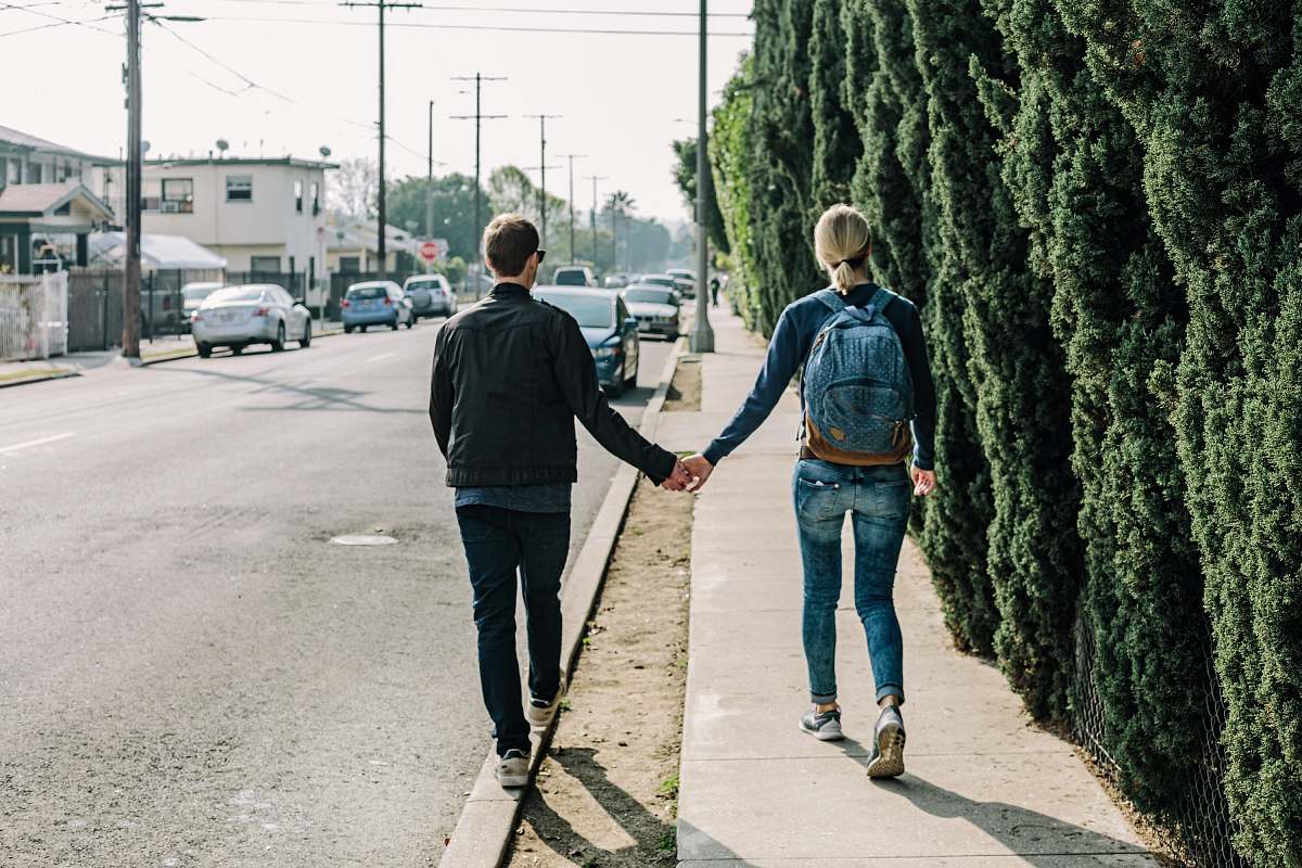 person man and woman walking on pathway during daytime people