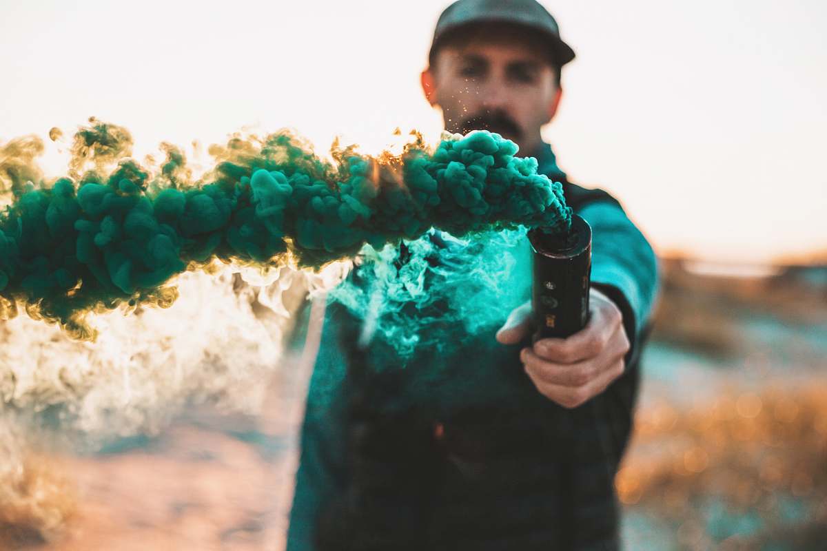 apparel man holding bottle with green smoke clothing