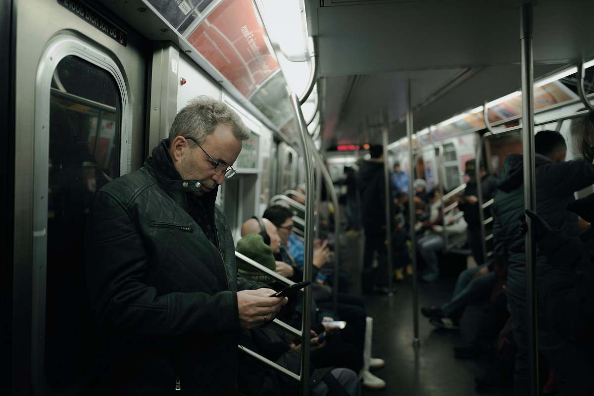 people man in gray coat standing near train door subway