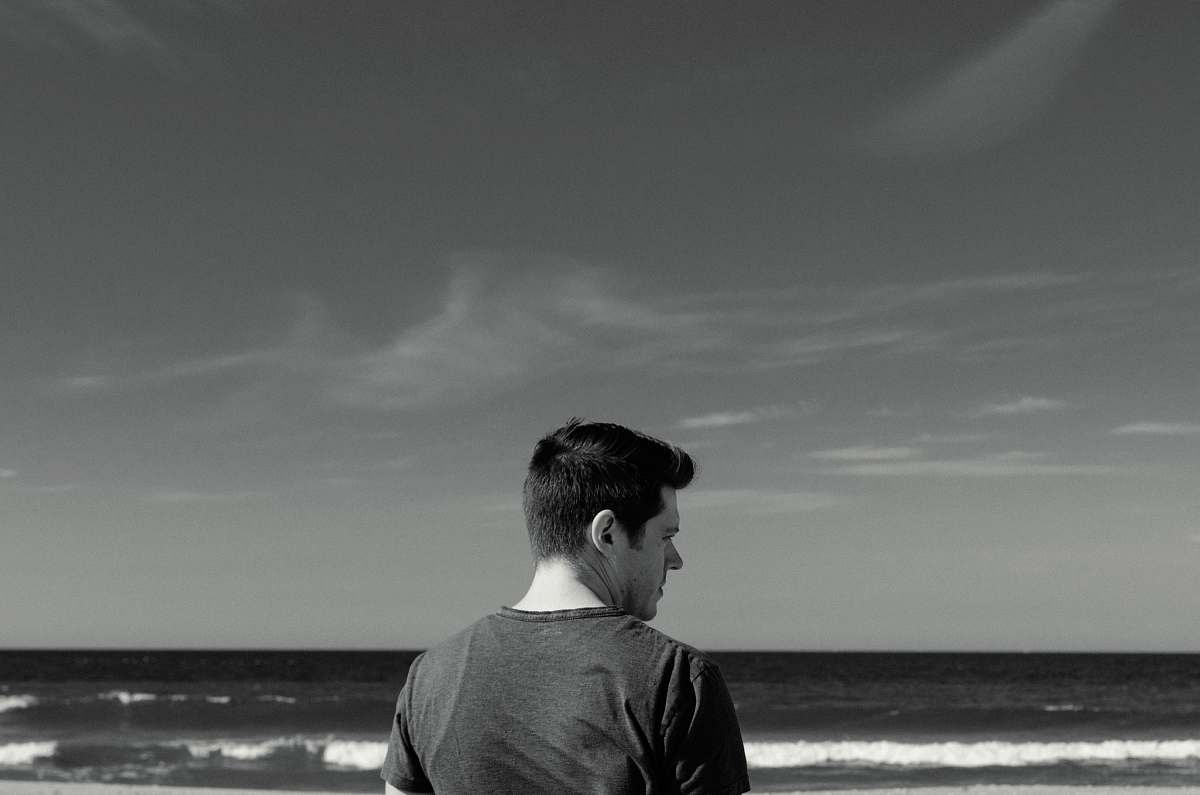 person man near ocean black-and-white