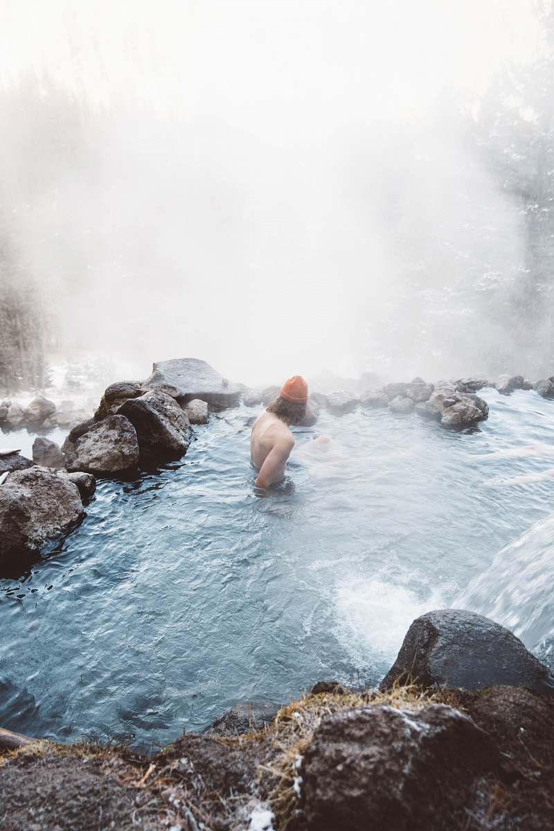 person man sitting in water with fog during daytime people