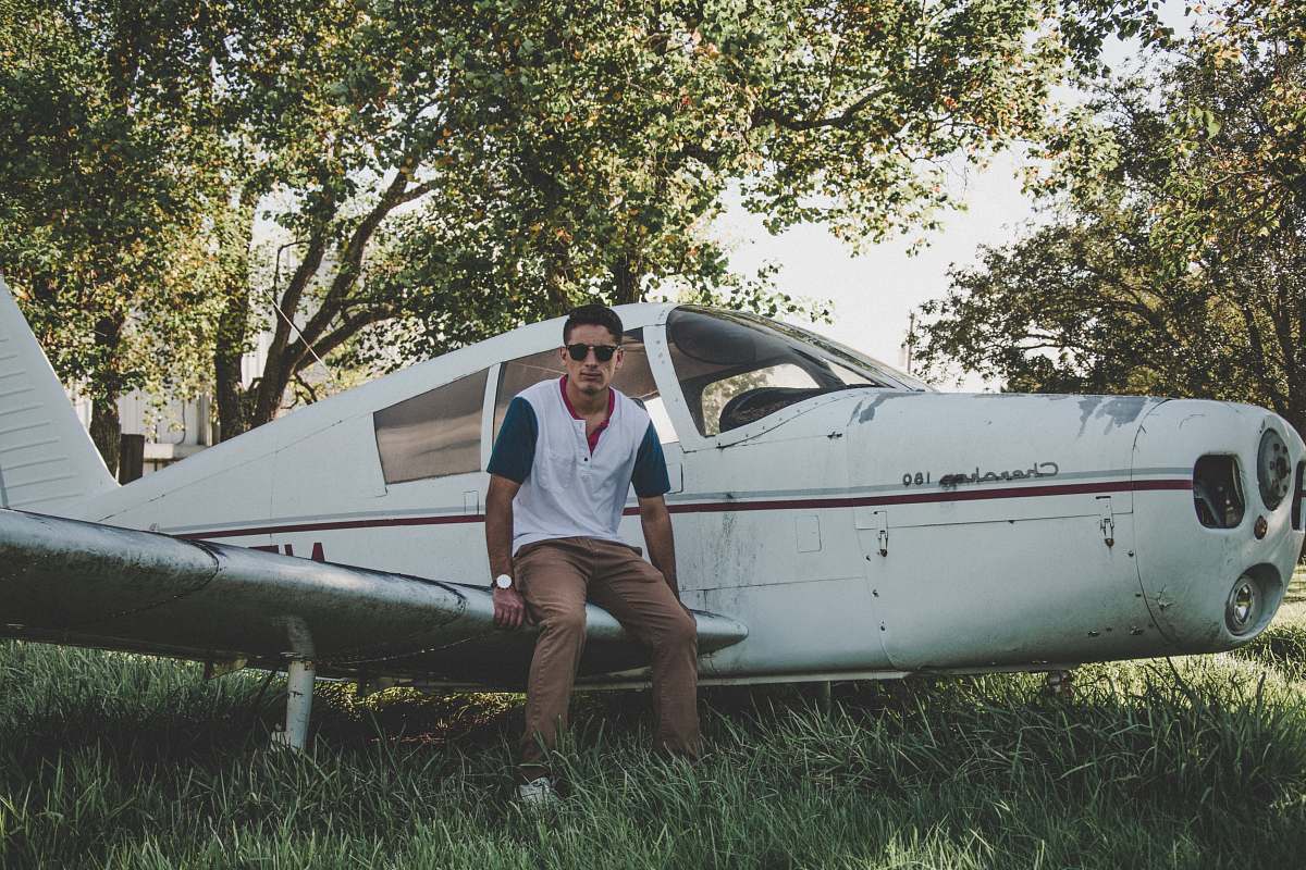 people man sitting on biplane wing person