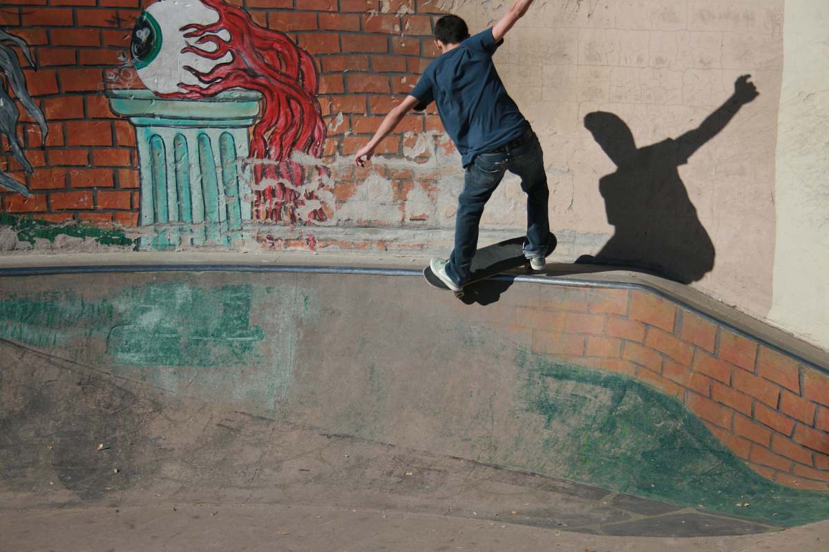 person man skateboarding on concrete rail people