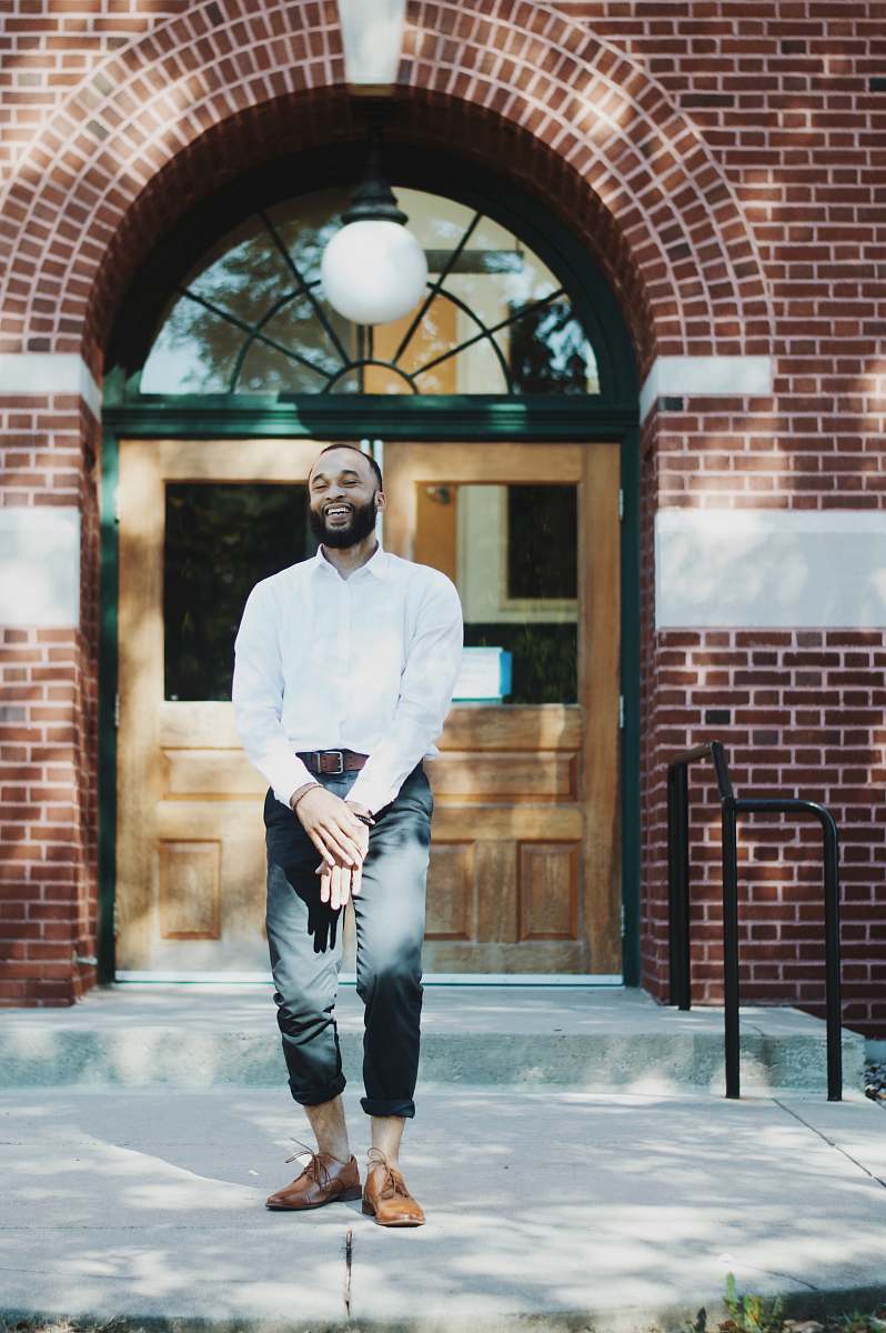 person man standing in front of brown wooden door during daytime people