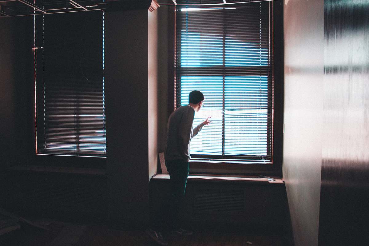 person man standing near window inside building people