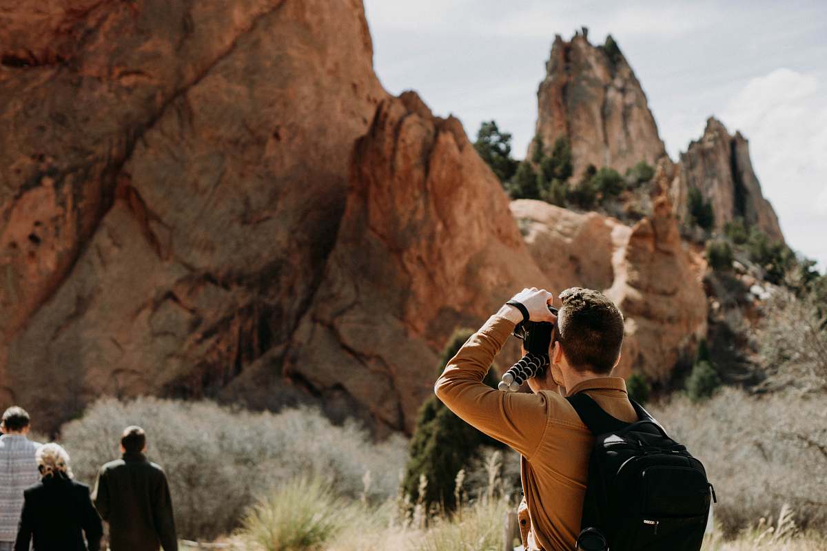 person man taking photo of rock formation people