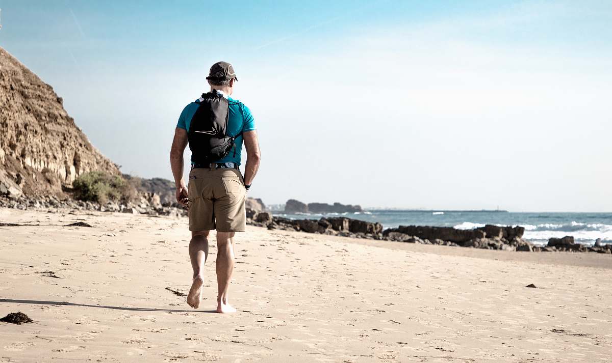 people man waling in front of beach person