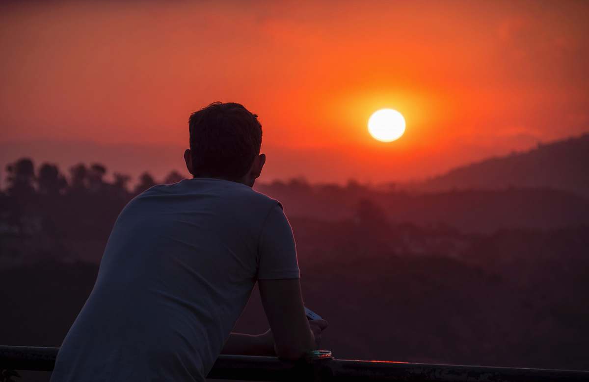 people man wearing blue shirt looking at sunset person