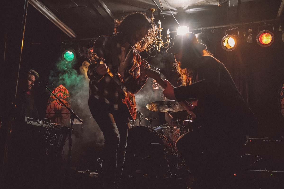 person men playing guitar on stage guitar