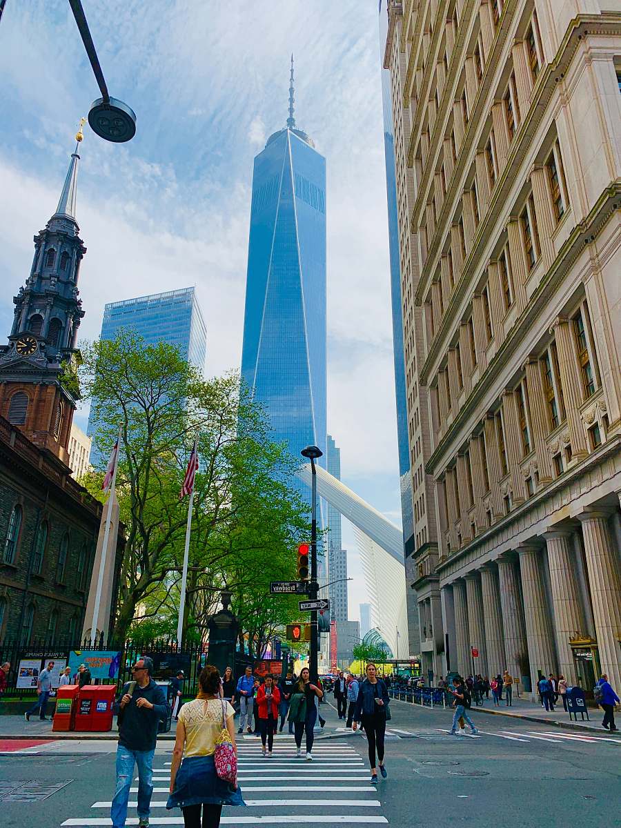 person people crossing across gray tower building town