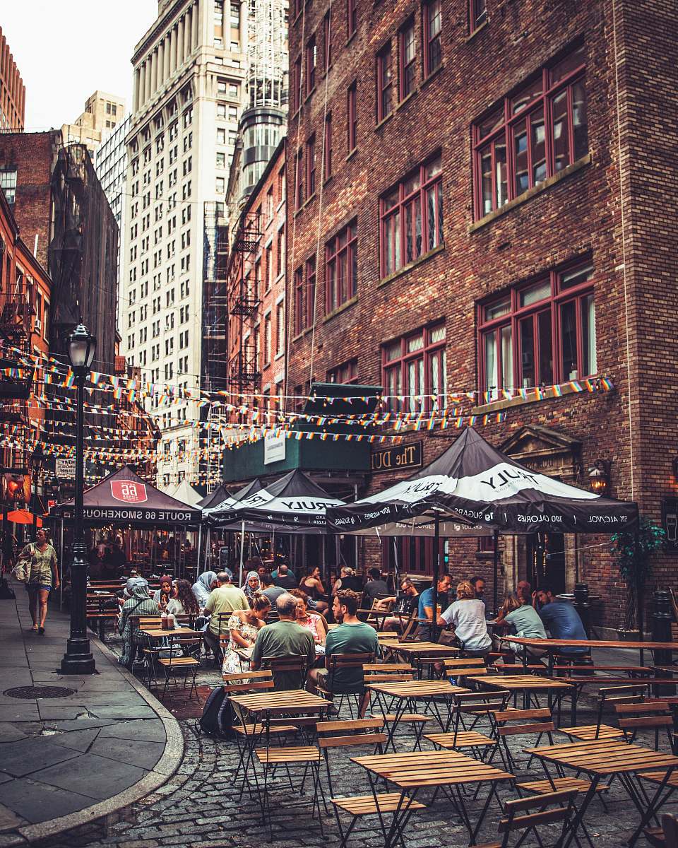 person people sitting near restaurant beside high-rise buildings restaurant