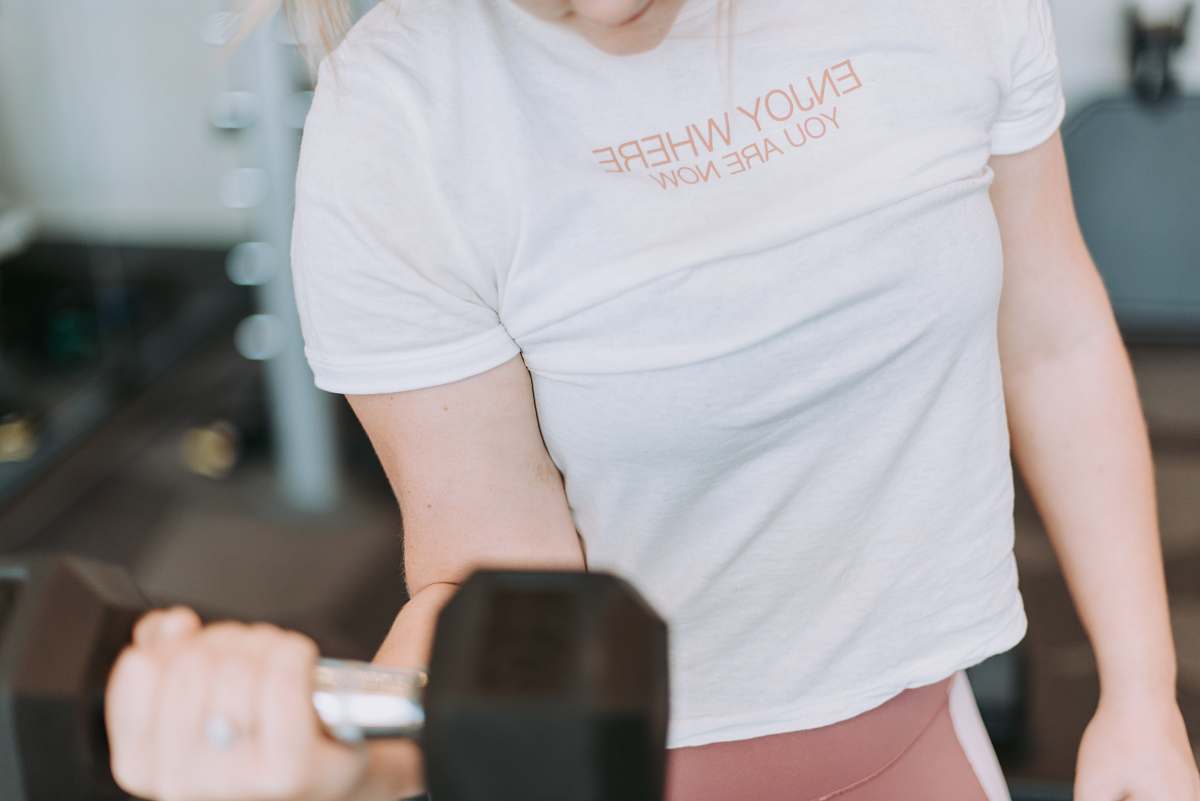 person person holding black dumbbell inside room people