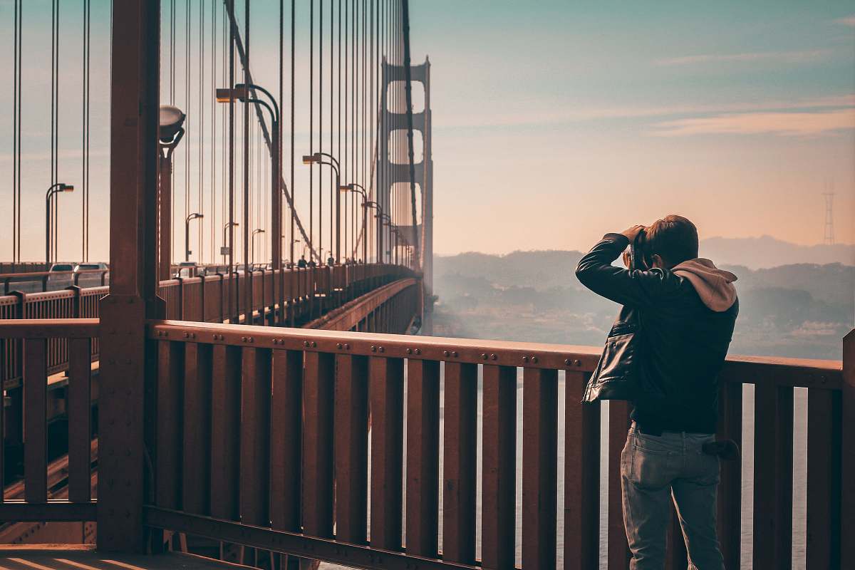 person person standing on bridge taking picture people