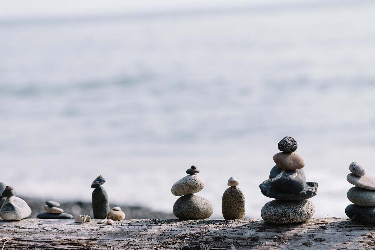 person shallow focus photo of balance stones pebble