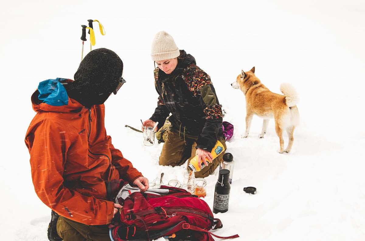 person two persons sitting on snowy ground apparel