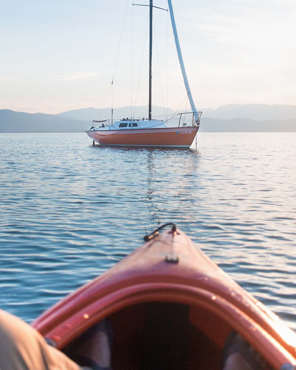 person white and orange scow on body of water people