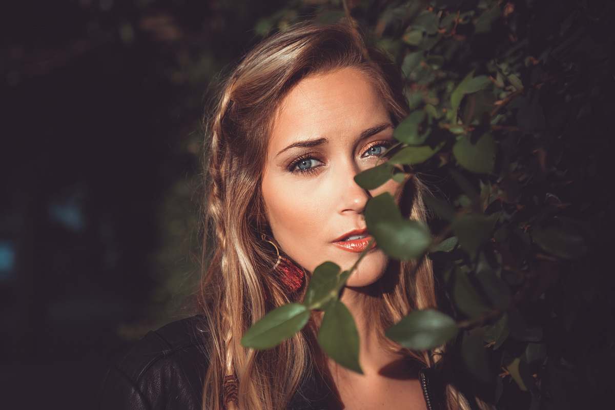people woman behind green leaf in selective focus photography person