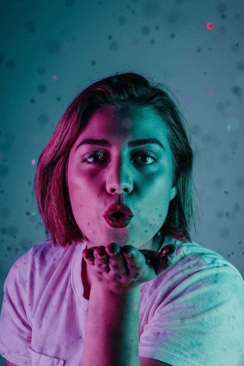 person woman blowing a flying kiss people