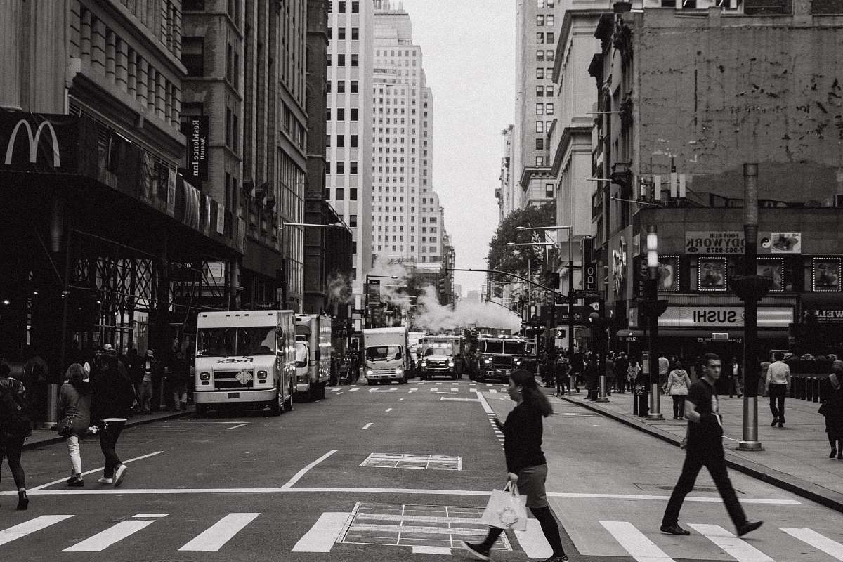 black-and-white woman in black top walking on roadway people