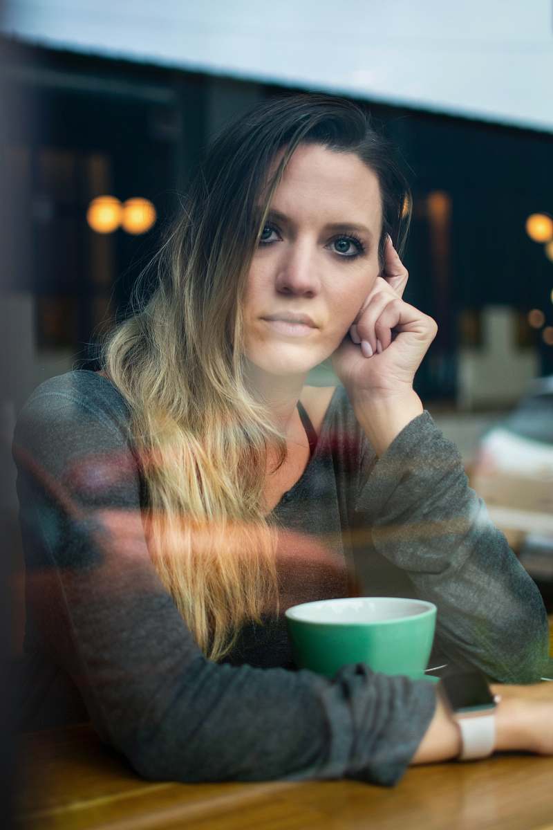 person woman in gray long-sleeved top sitting on chair people
