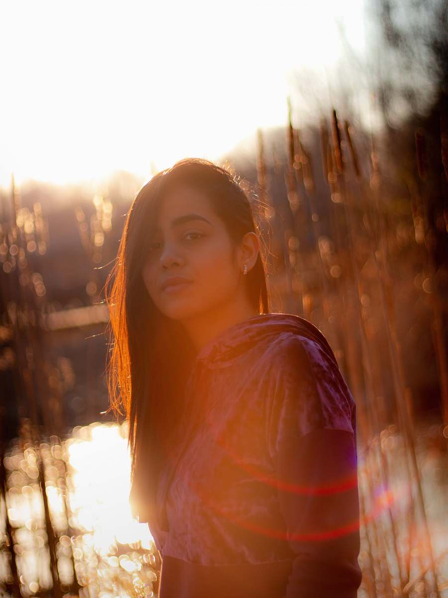flare woman in pink shirt standing near trees during daytime light