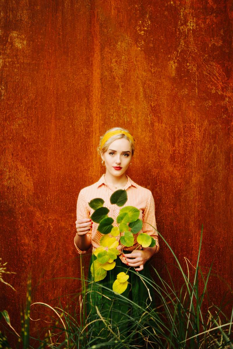 person woman in white long sleeve shirt holding yellow flower plant