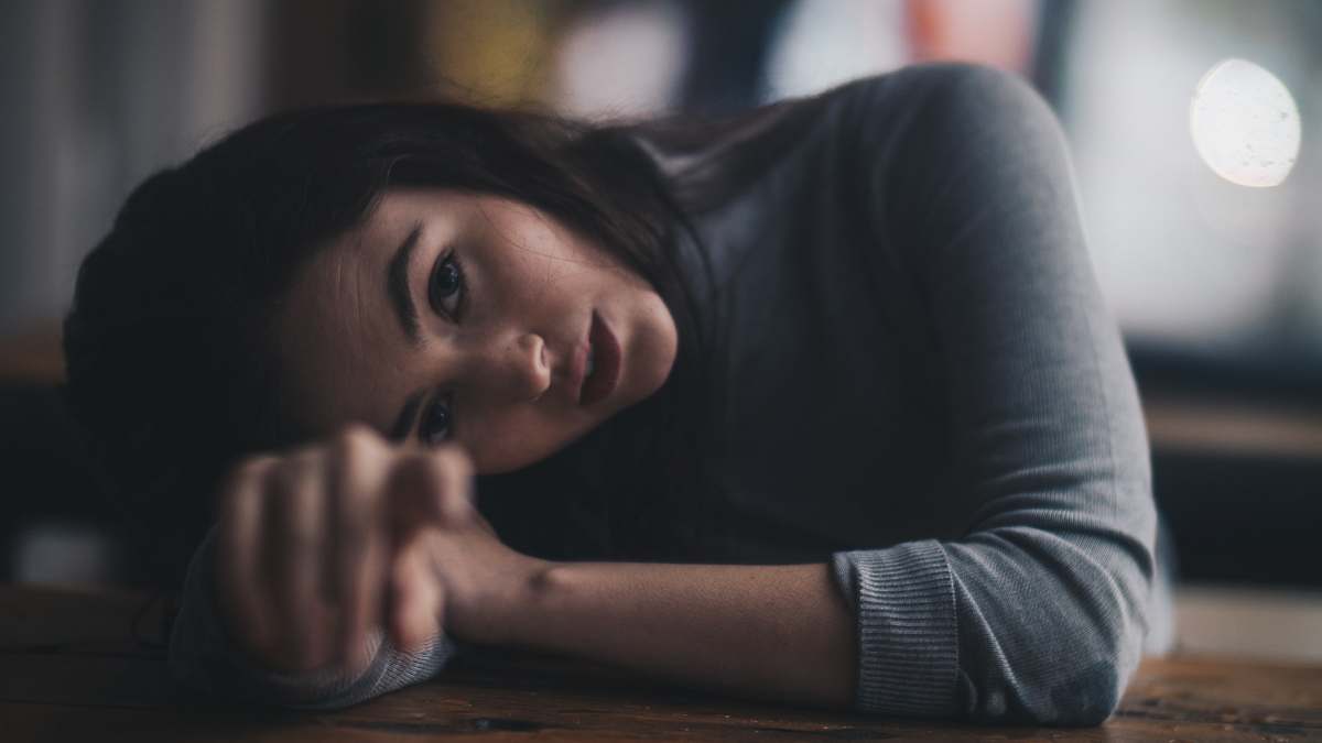 person woman leaning on brown wooden surface people