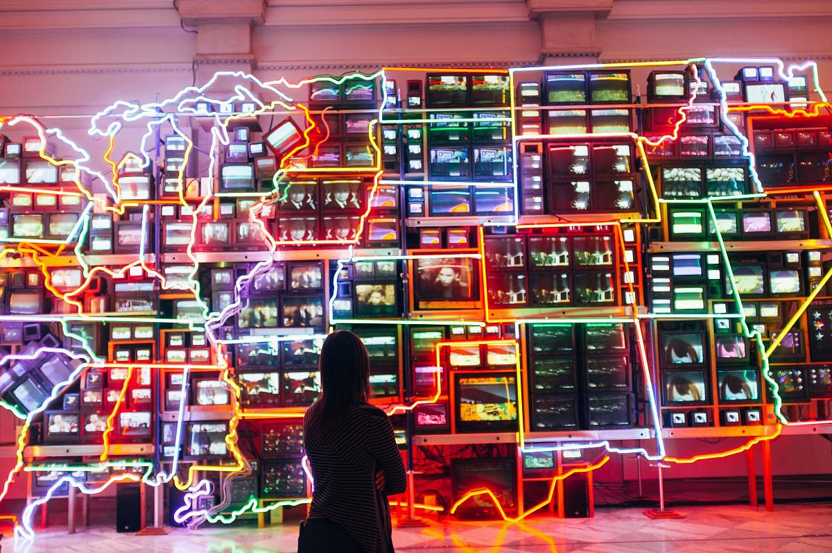 person woman looking at monitors with light decor people