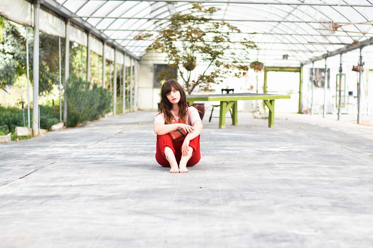 person woman sitting on gray concrete surface posing for photo people