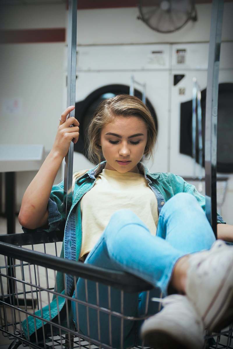 person woman sitting on grocery cart people