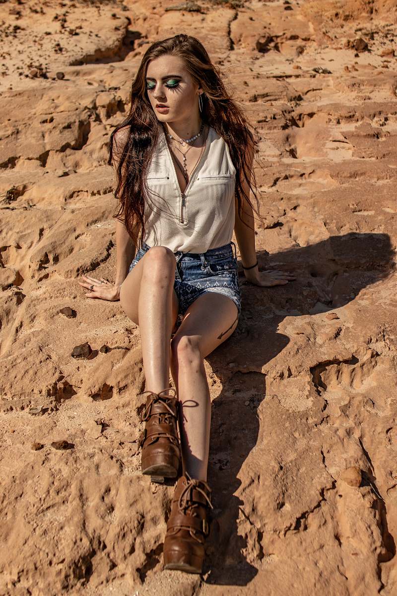 apparel woman sitting on rock during daytime clothing