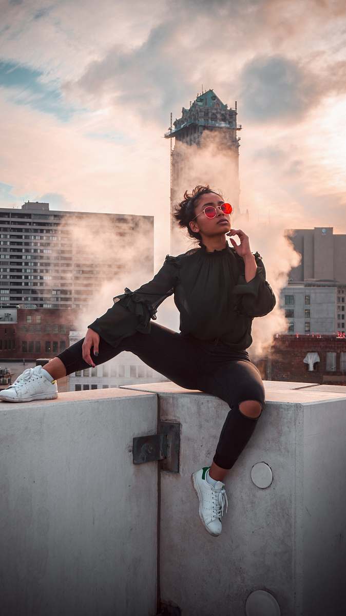 person woman sitting on white wall outdoor people