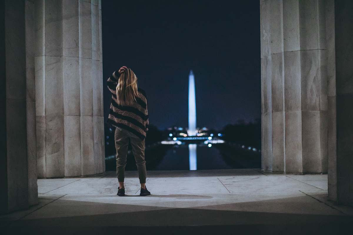 person woman standing inside building facing tower landmark people
