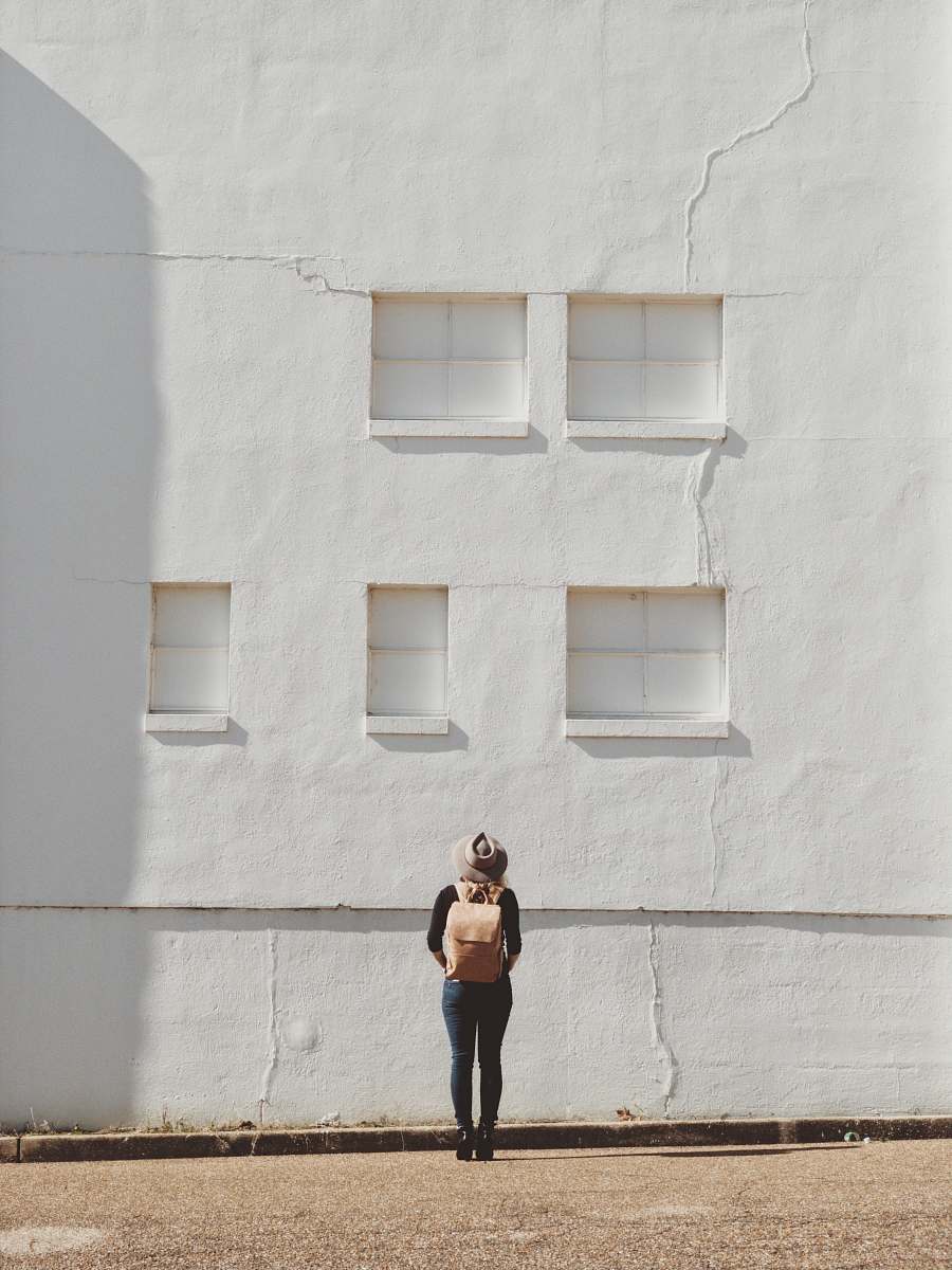 person woman standing on front of white building photographer