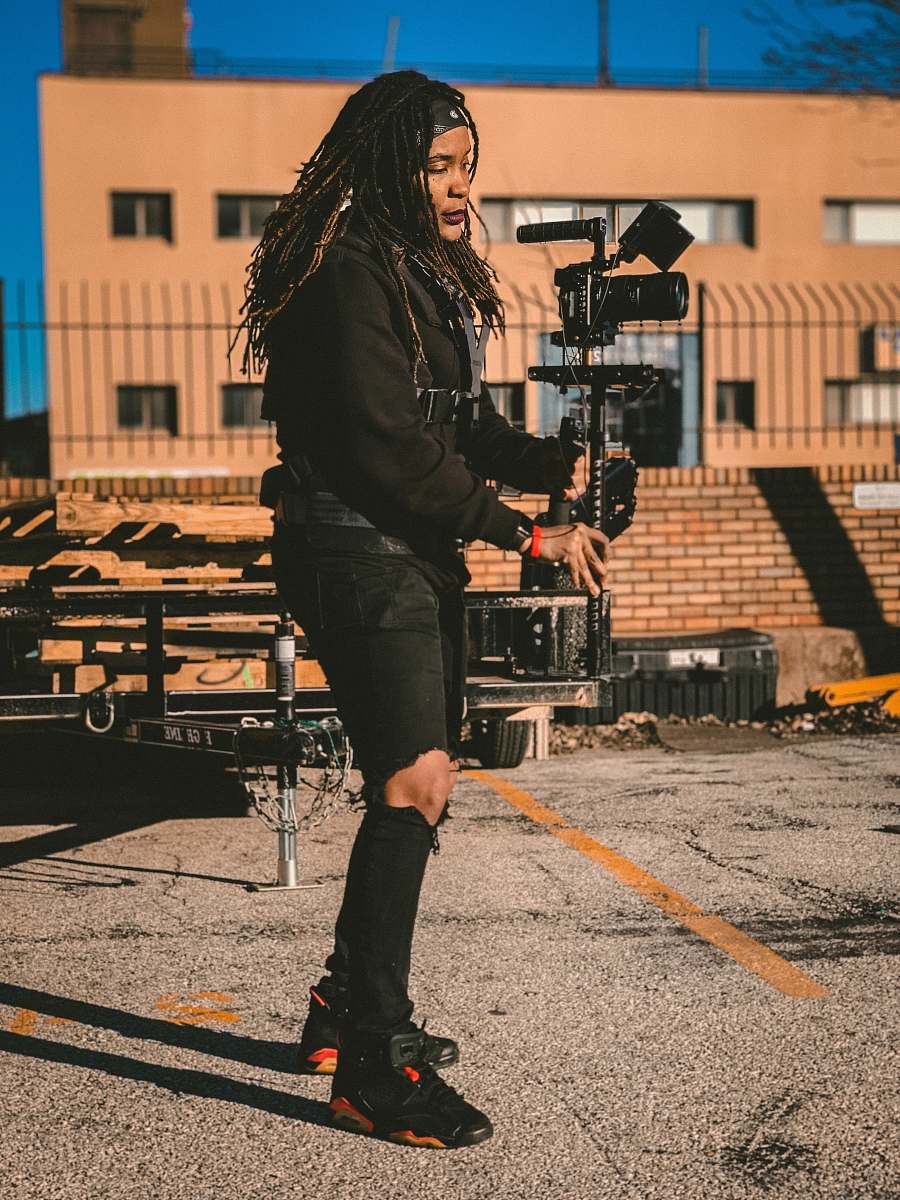 person woman wearing black ripped jeans holding camera apparel