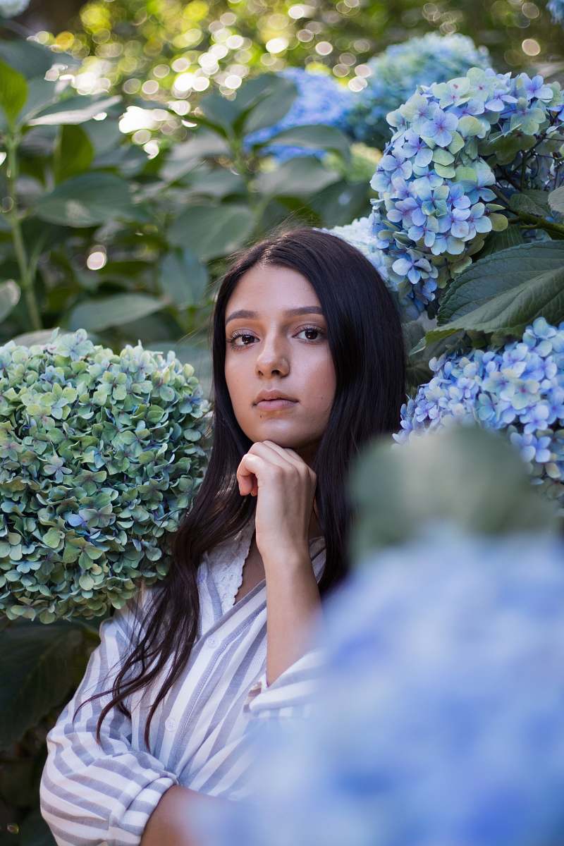 person woman with chin on hand surrounded by plants people